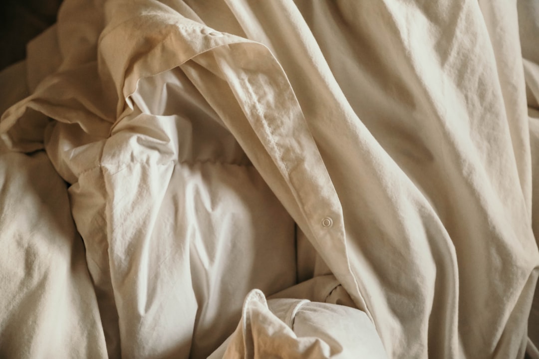 an-unmade-bed-with-white-sheets-and-pillows-kbje159aomi